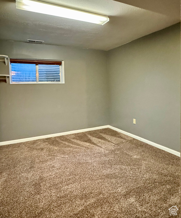Carpeted empty room with baseboards