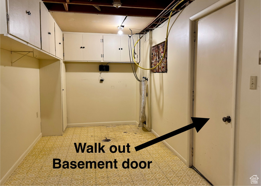Washroom with cabinet space and baseboards