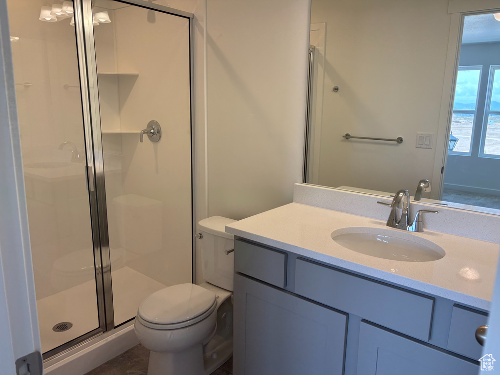 Full bath featuring toilet, a stall shower, and vanity
