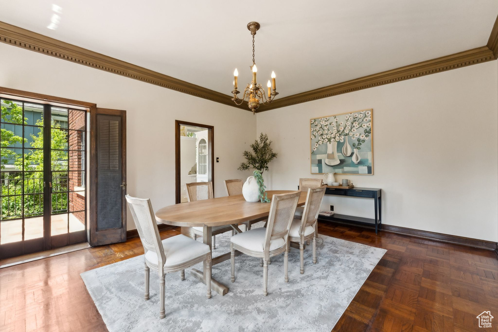 Dining room featuring a chandelier, ornamental molding, and baseboards