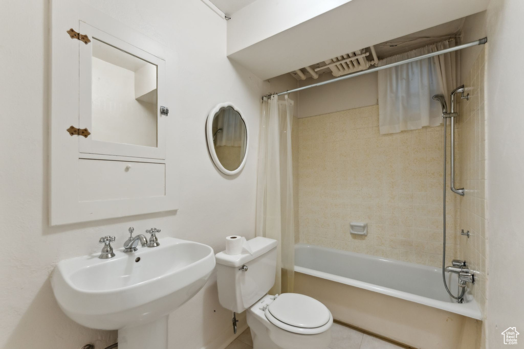 Full bath with toilet, shower / tub combo, a sink, and tile patterned floors
