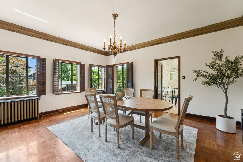 Dining room featuring radiator heating unit, baseboards, a chandelier, and ornamental molding