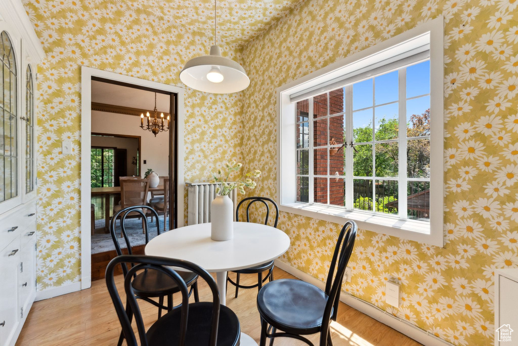 Dining area featuring light wood-style flooring, a chandelier, and baseboards