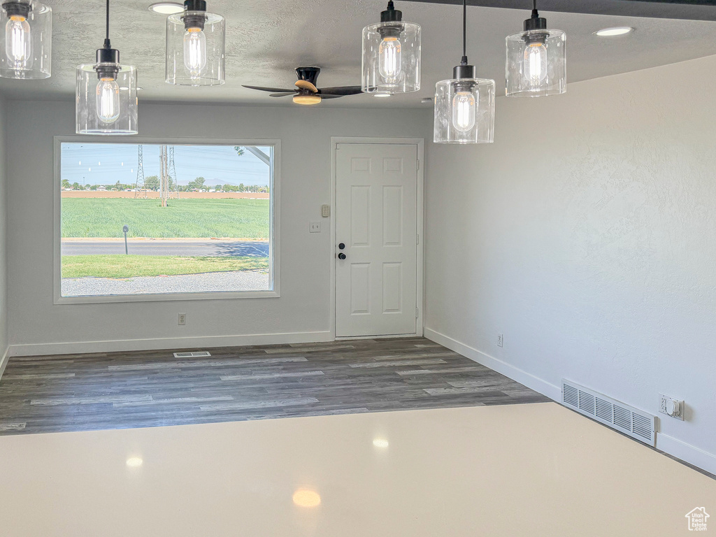 Unfurnished dining area with baseboards, wood finished floors, and ceiling fan