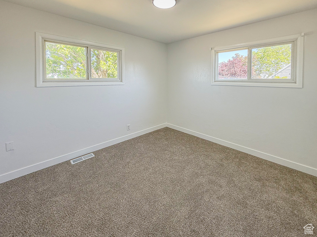 Carpeted empty room featuring baseboards