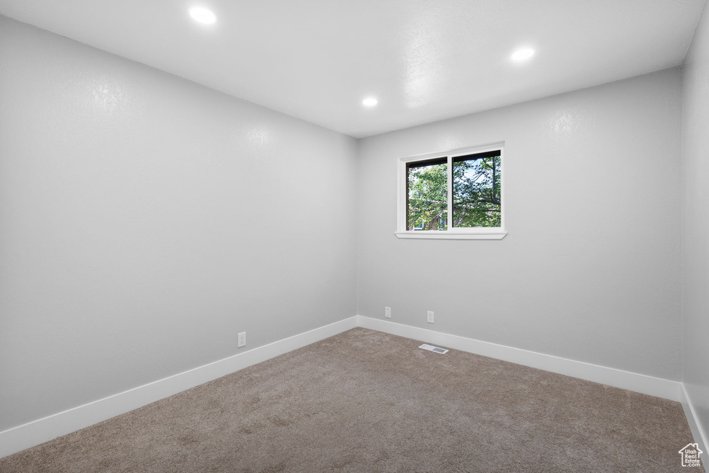 Carpeted spare room with recessed lighting and baseboards
