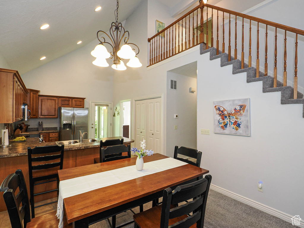 Dining area featuring high vaulted ceiling, a chandelier, baseboards, recessed lighting, and stairway