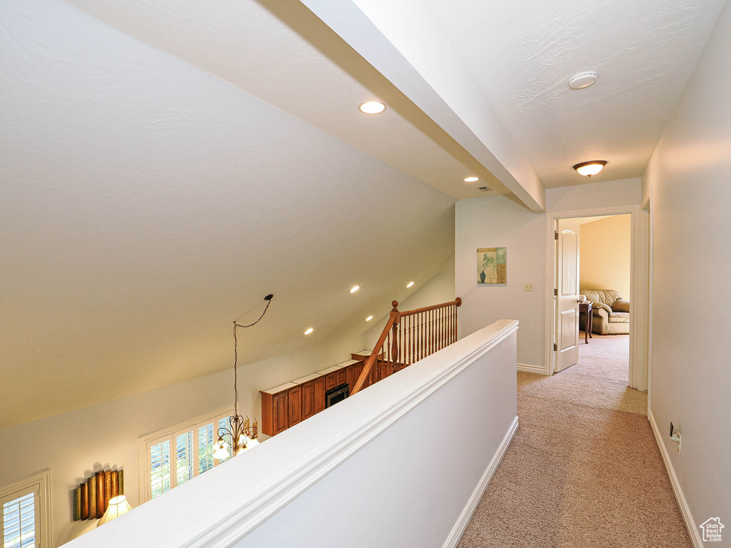 Corridor with an upstairs landing, light carpet, recessed lighting, baseboards, and plenty of natural light