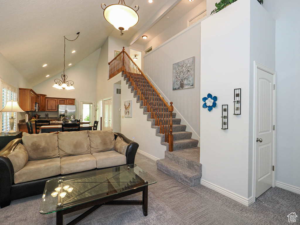 Carpeted living area with high vaulted ceiling, recessed lighting, stairway, baseboards, and healthy amount of natural light