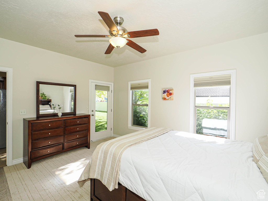 Bedroom featuring light carpet, ceiling fan, and baseboards
