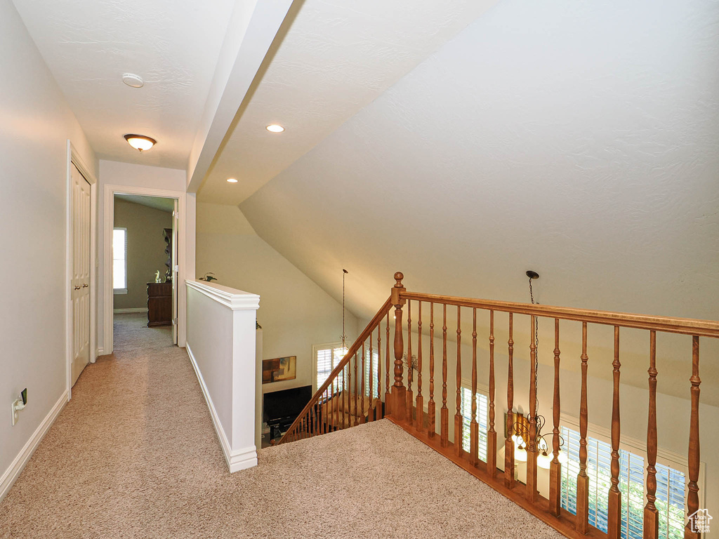 Hallway featuring an upstairs landing, light colored carpet, baseboards, lofted ceiling, and recessed lighting