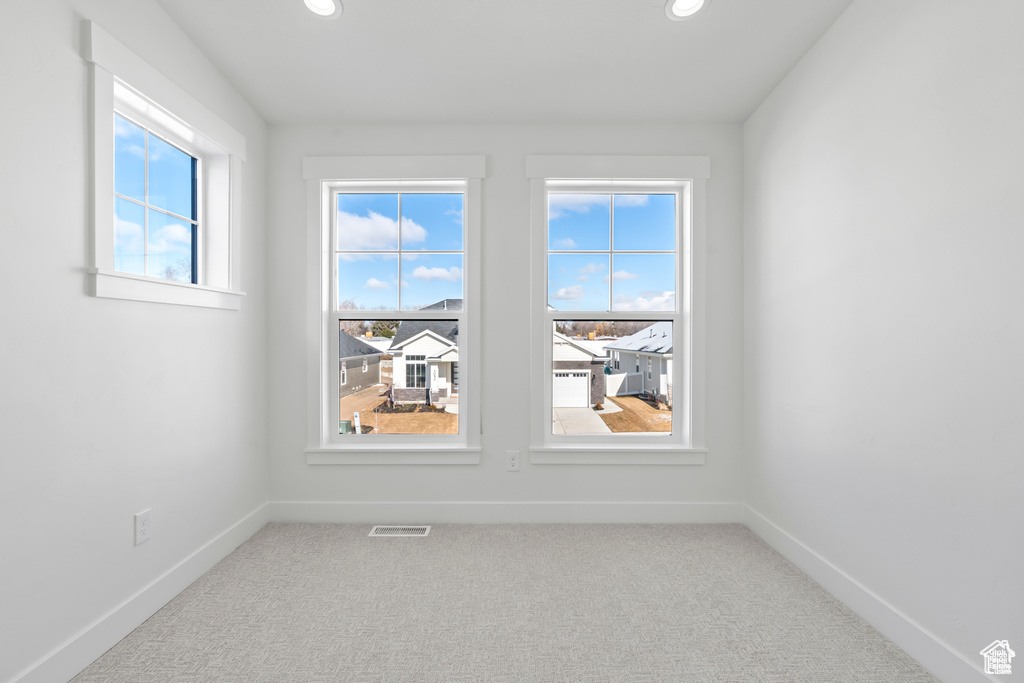 Carpeted empty room with plenty of natural light, baseboards, and recessed lighting