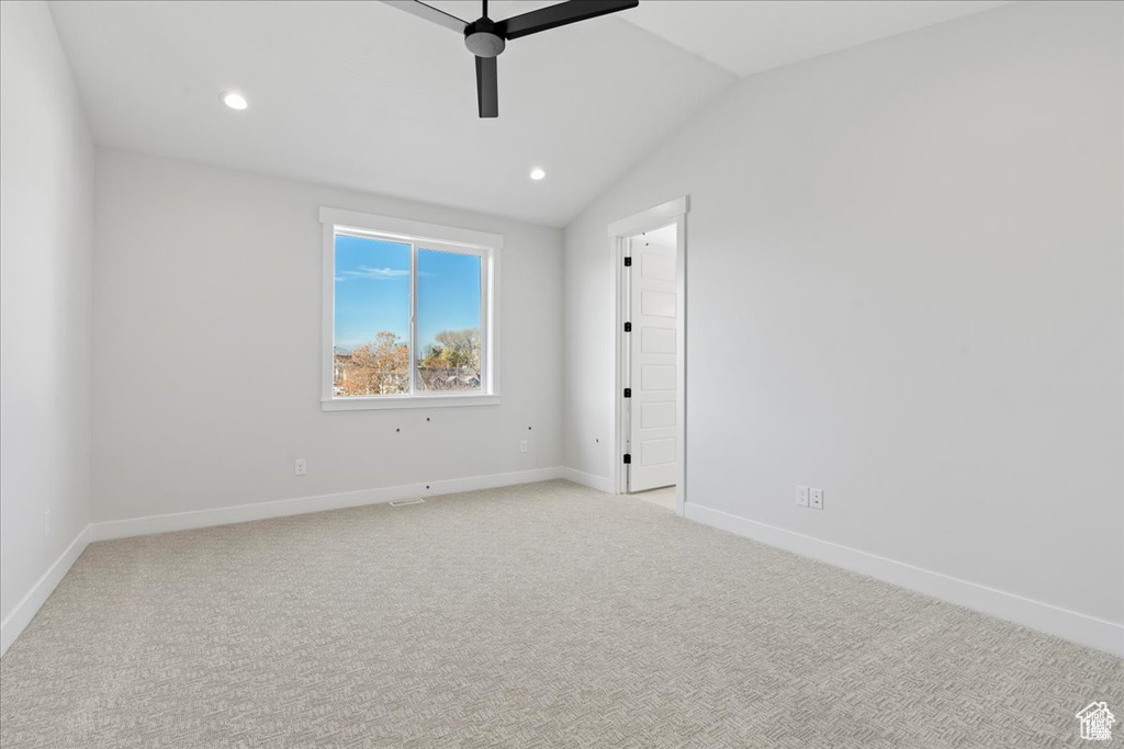 Spare room featuring ceiling fan, light carpet, baseboards, lofted ceiling, and recessed lighting