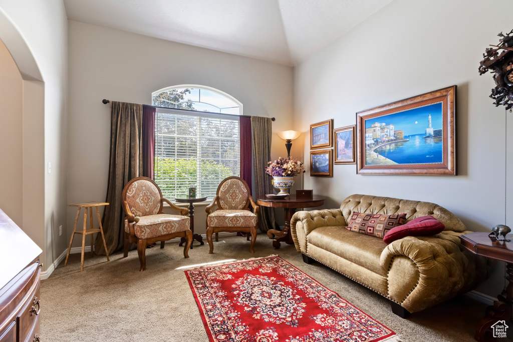 Sitting room with arched walkways, carpet floors, and high vaulted ceiling