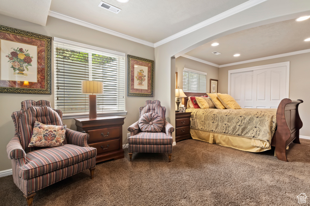 Carpeted bedroom with arched walkways, recessed lighting, crown molding, baseboards, and a closet