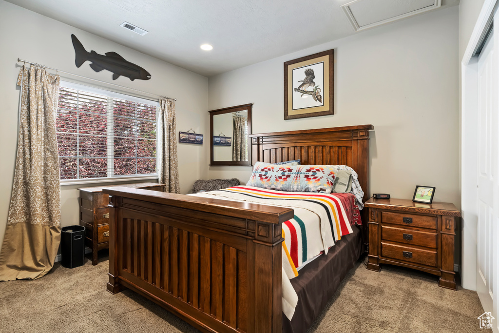 Bedroom with light colored carpet, attic access, and recessed lighting