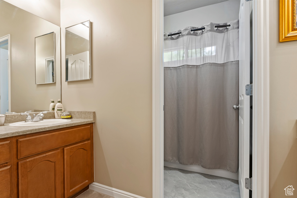 Full bathroom with vanity and marble look tiles