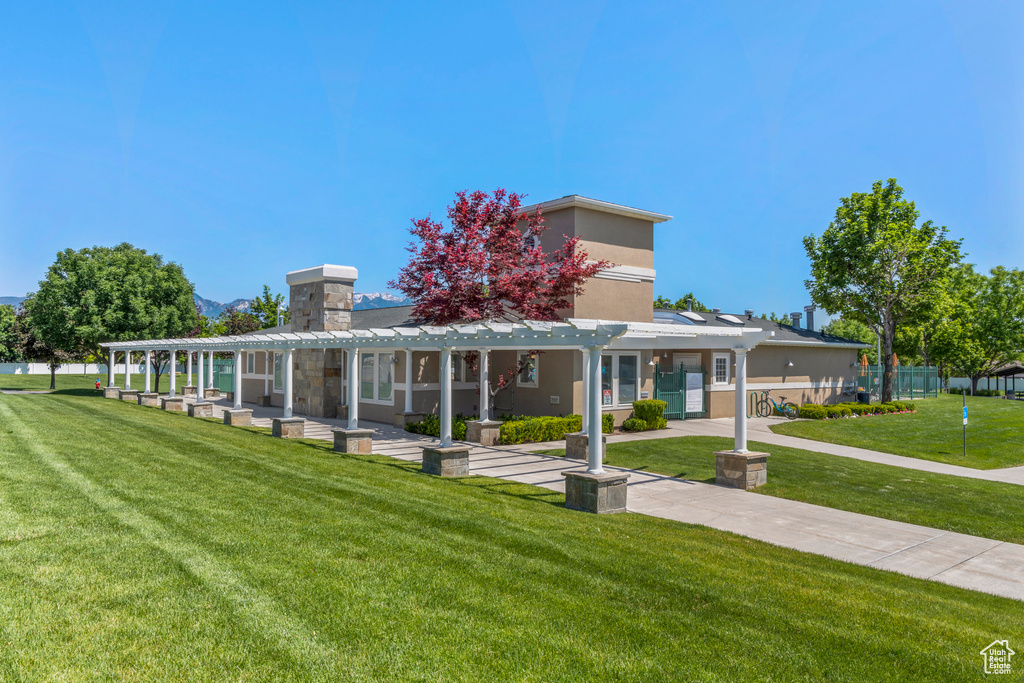 View of property\'s community featuring a pergola and a yard
