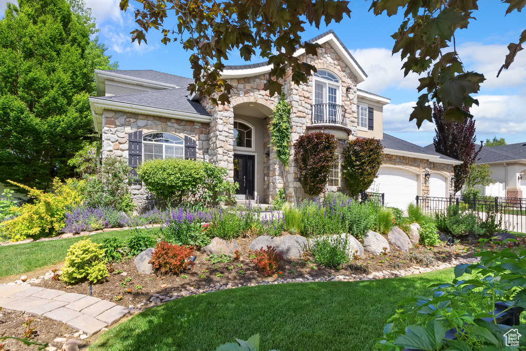 View of front of house with stone siding and a garage