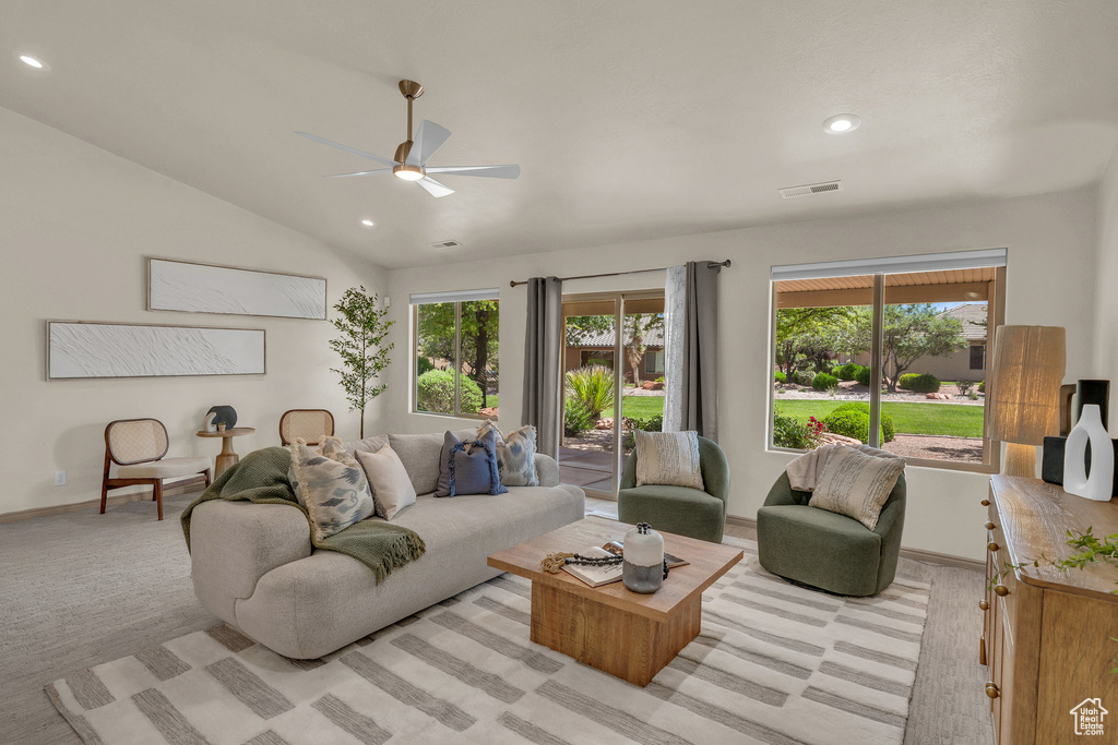 Living room with ceiling fan, recessed lighting, baseboards, lofted ceiling, and light colored carpet