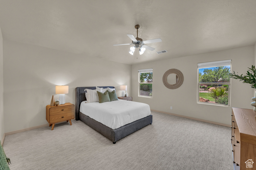 Bedroom featuring baseboards, light colored carpet, and ceiling fan