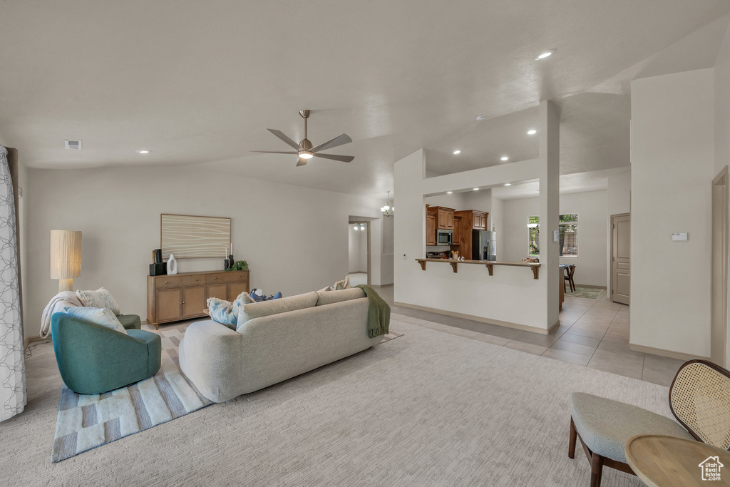 Living room with vaulted ceiling, a ceiling fan, recessed lighting, light tile patterned floors, and baseboards