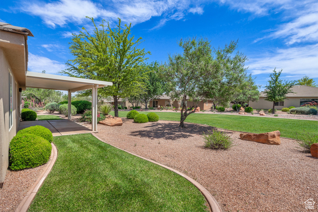 View of green lawn with a patio area