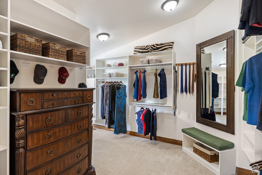Spacious closet featuring light carpet and lofted ceiling