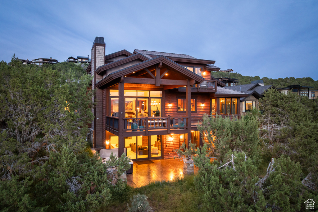 Rear view of property with a chimney and a balcony