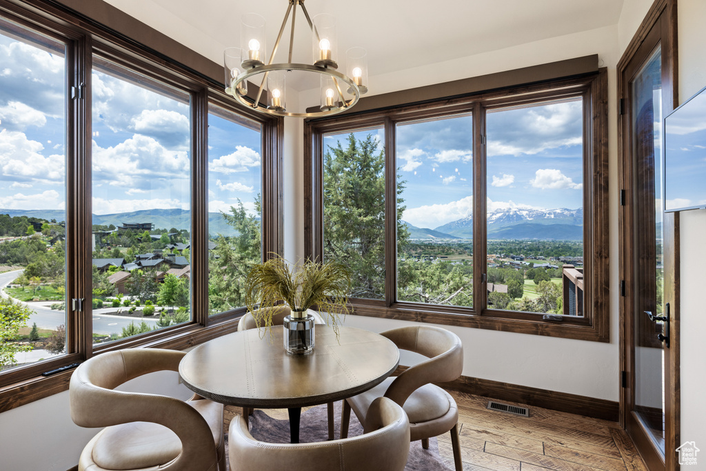 Dining room with a chandelier, a mountain view, baseboards, and light wood-type flooring
