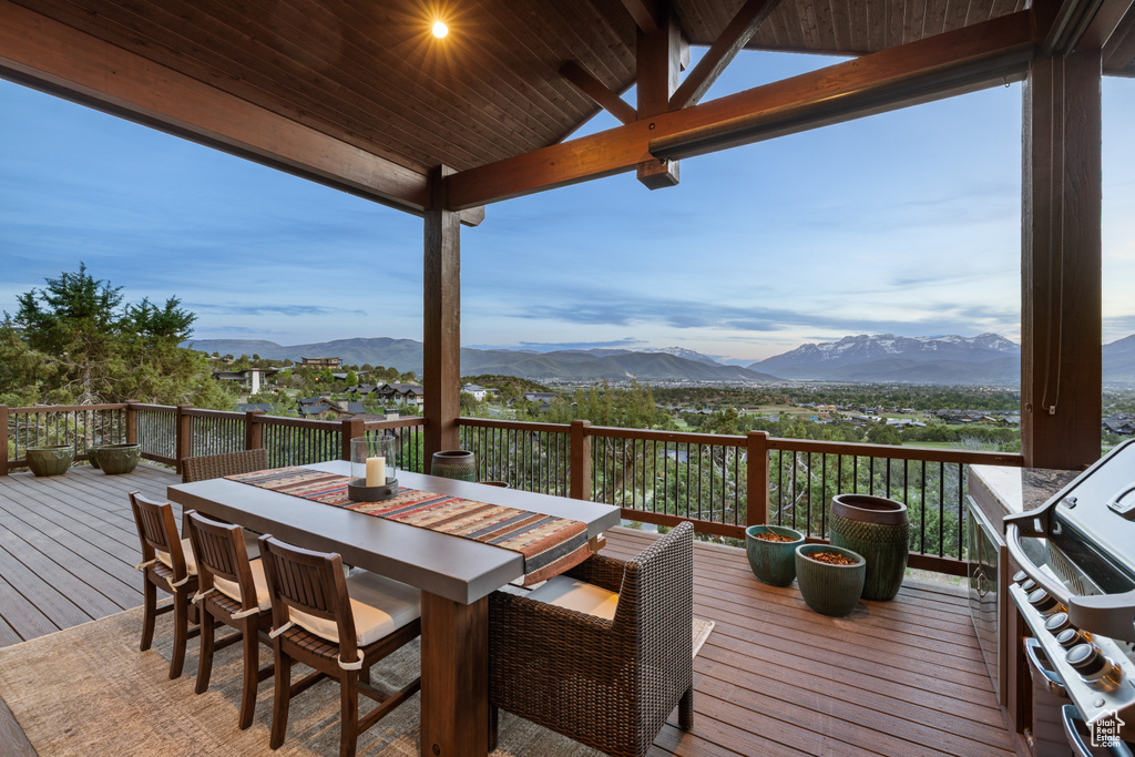 Wooden terrace with a mountain view, a grill, and outdoor dining area