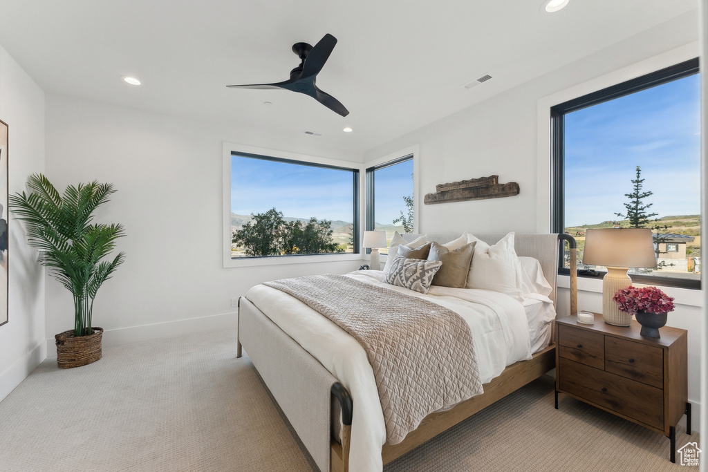 Carpeted bedroom featuring multiple windows, recessed lighting, and a ceiling fan