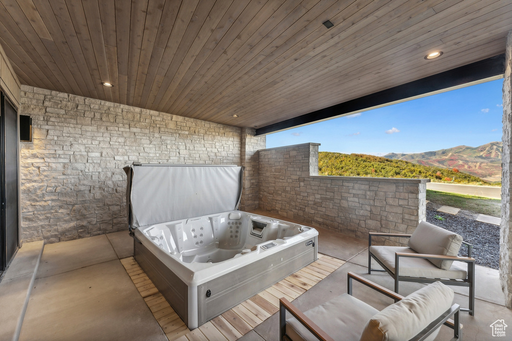View of patio featuring a hot tub and a mountain view