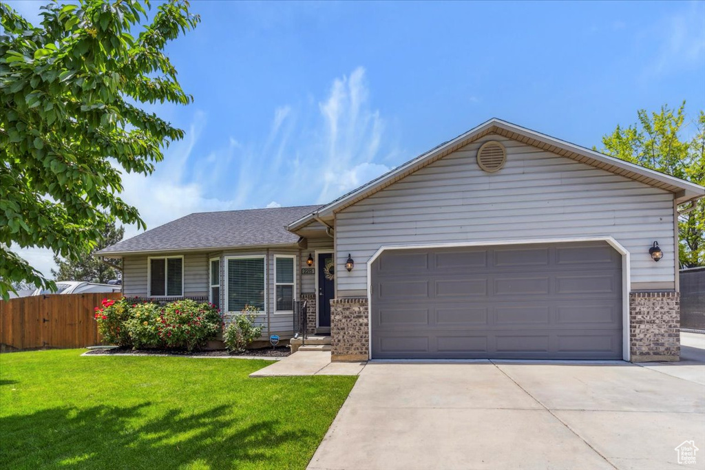 Single story home featuring brick siding, an attached garage, concrete driveway, and a shingled roof