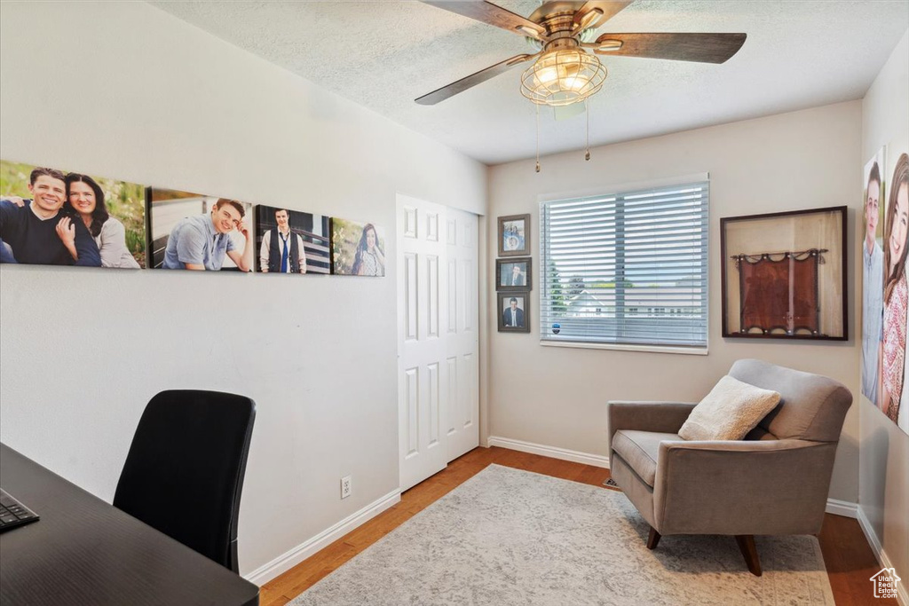 Office area with wood finished floors, ceiling fan, and baseboards