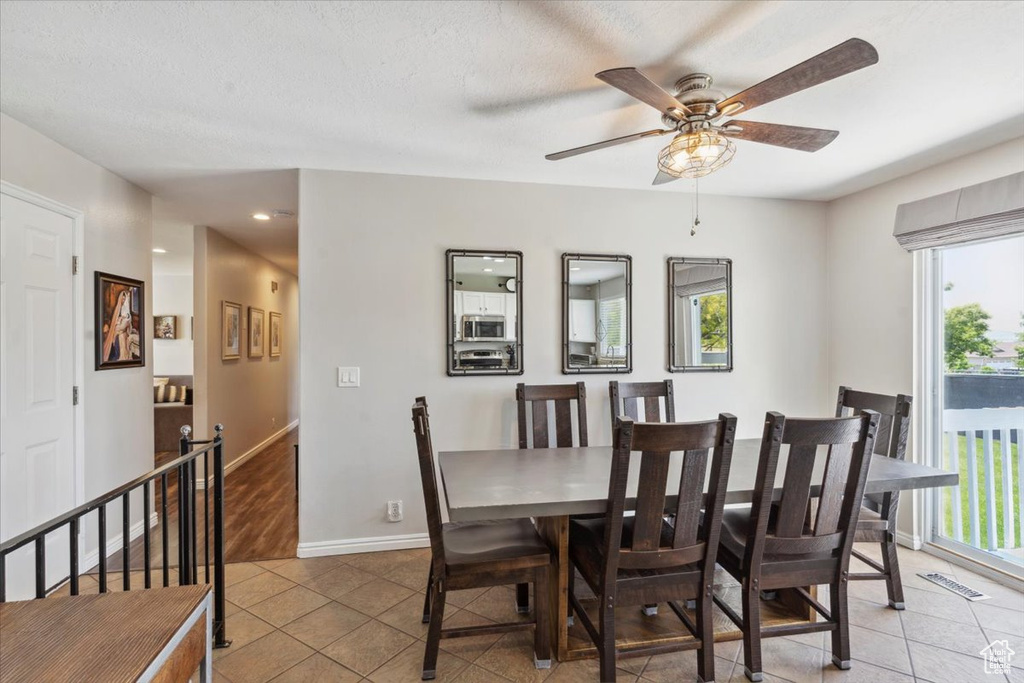 Dining space featuring light tile patterned flooring, a ceiling fan, baseboards, and recessed lighting