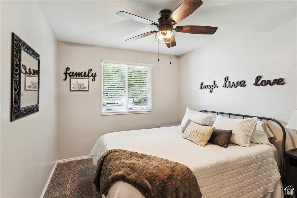 Carpeted bedroom with baseboards and ceiling fan