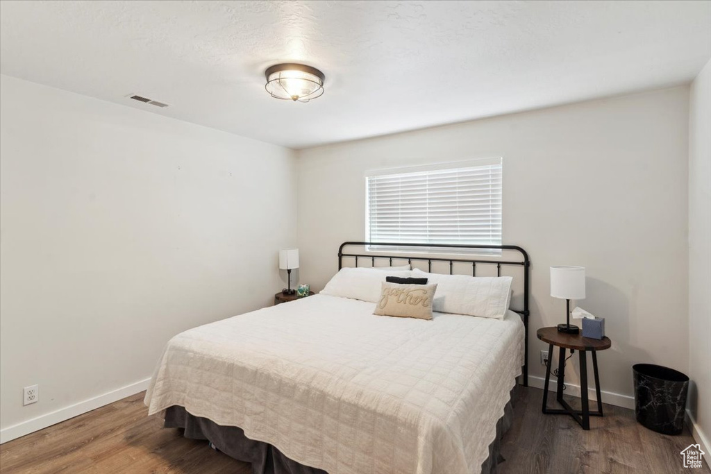 Bedroom with wood finished floors and baseboards