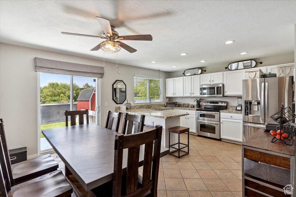 Dining space featuring ceiling fan, recessed lighting, a textured ceiling, and light tile patterned floors