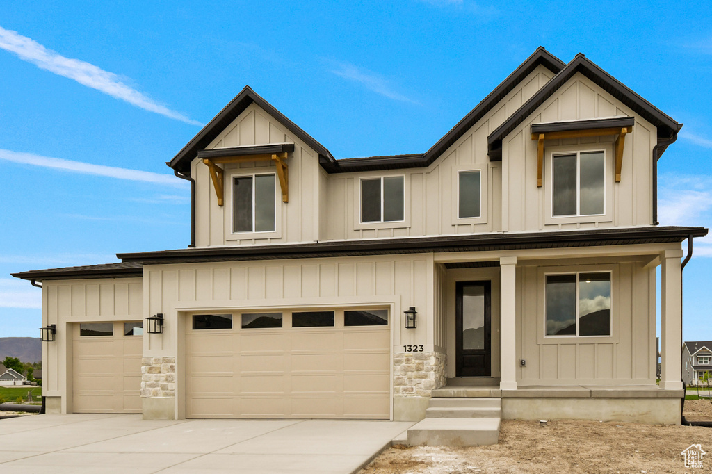 View of front of house with concrete driveway and board and batten siding