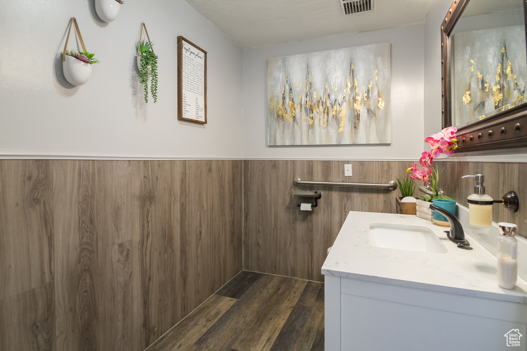 Bathroom with vanity, wood finished floors, and a wainscoted wall