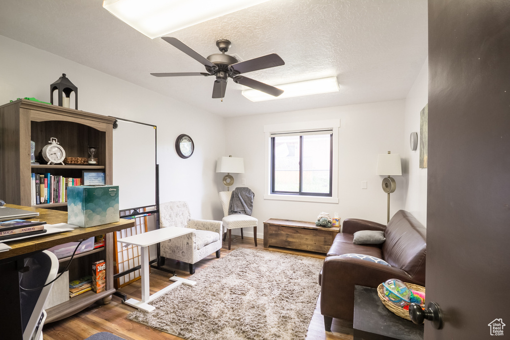 Living area featuring ceiling fan and wood finished floors
