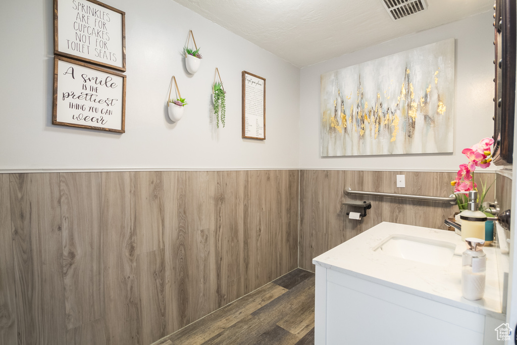 Bathroom featuring vanity, a wainscoted wall, and wood finished floors