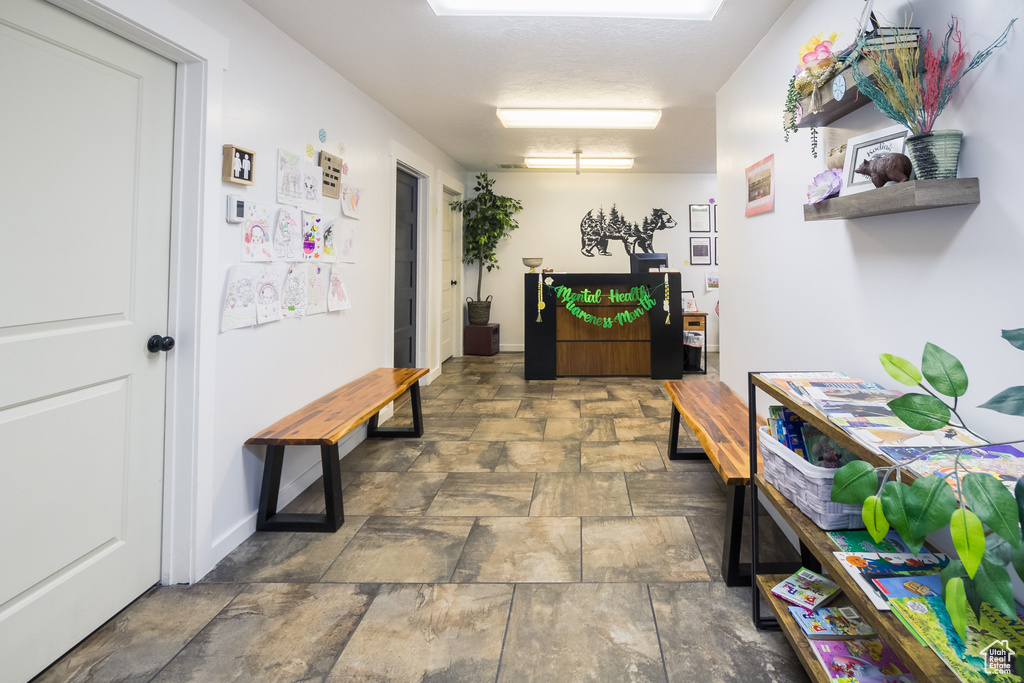 Corridor featuring stone finish floors and baseboards
