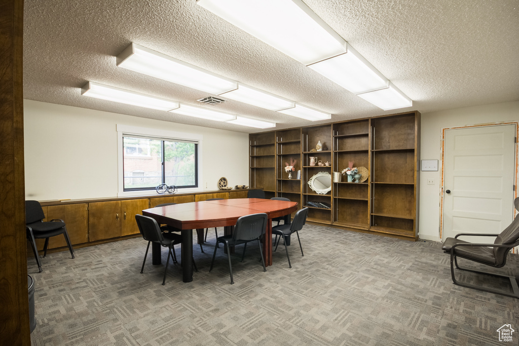 Dining room with a textured ceiling and carpet floors