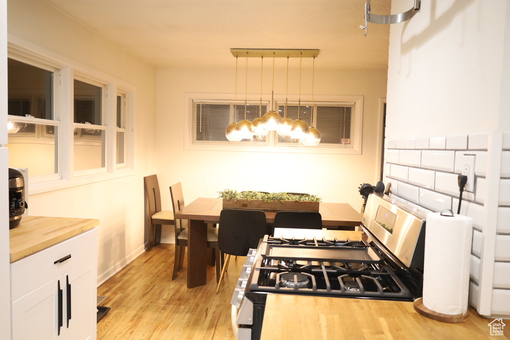 Dining area featuring light wood-style floors, a chandelier, and baseboards