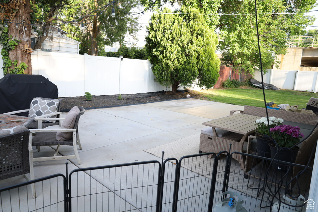 Fenced backyard featuring grilling area, a patio area, and a gate