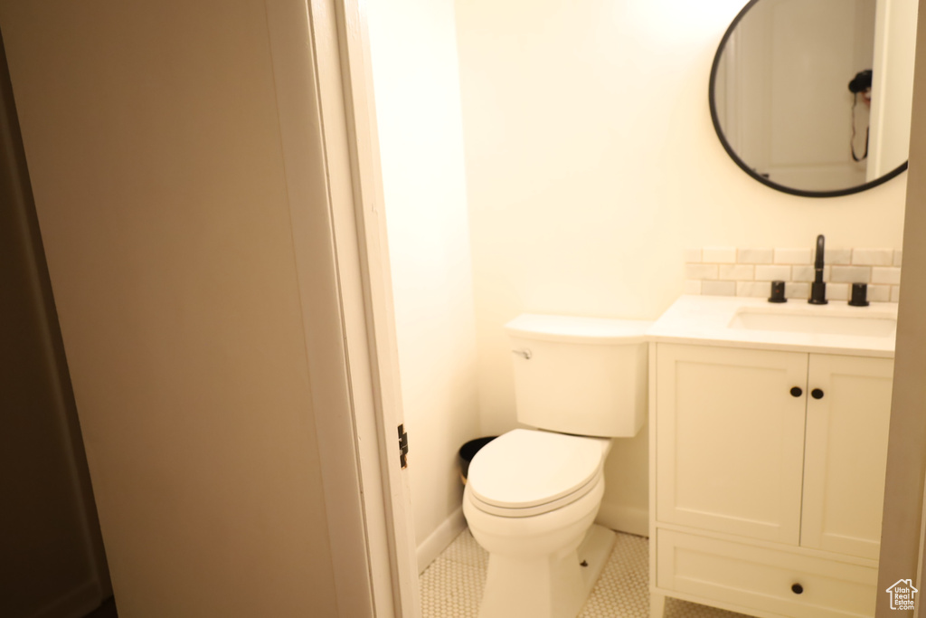 Bathroom featuring vanity, tasteful backsplash, toilet, and tile patterned flooring