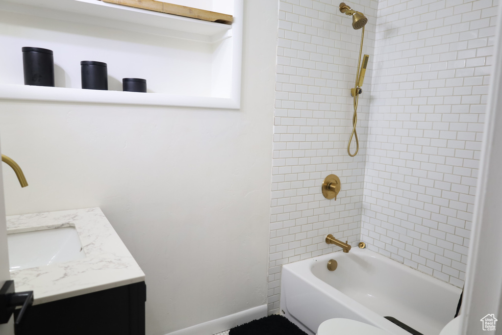 Bathroom featuring vanity,  shower combination, toilet, and baseboards
