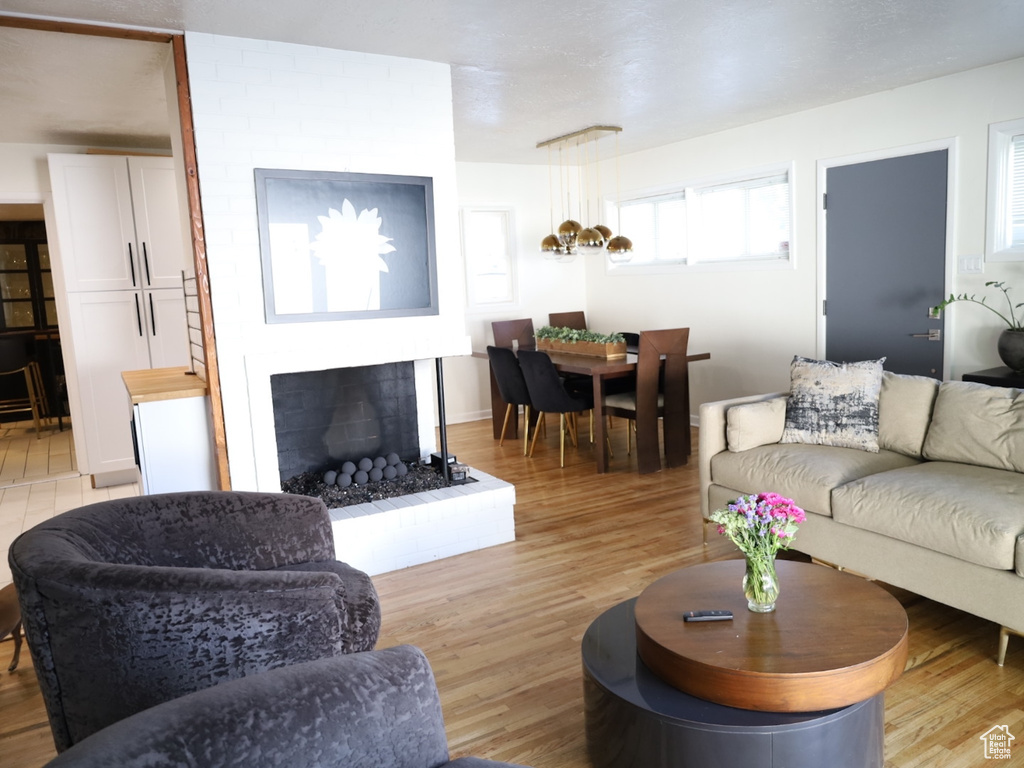 Living room featuring light wood-type flooring and a fireplace with raised hearth